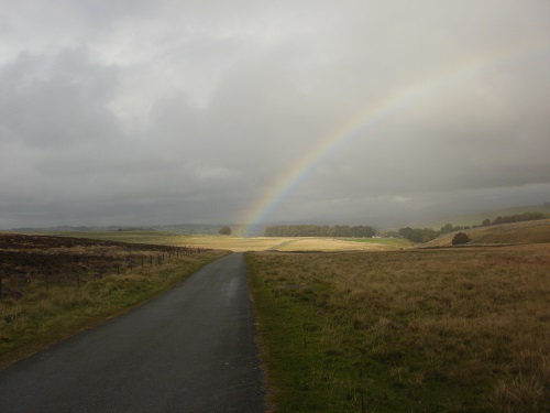 A rainbow shines onto the road from Orton