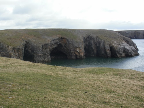Some caves in the water beneath the flat cliffs