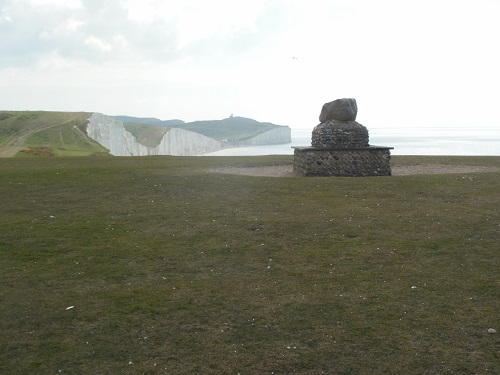 The Sarsen Stone monument with Belle Tout lighthouse in the distance