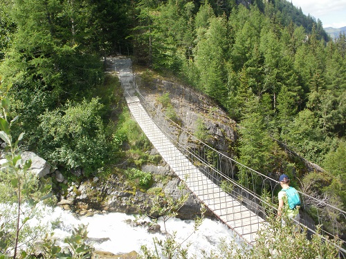 The bridge over the torrent caused by the melting ice of the Glacier du Bionnassay
